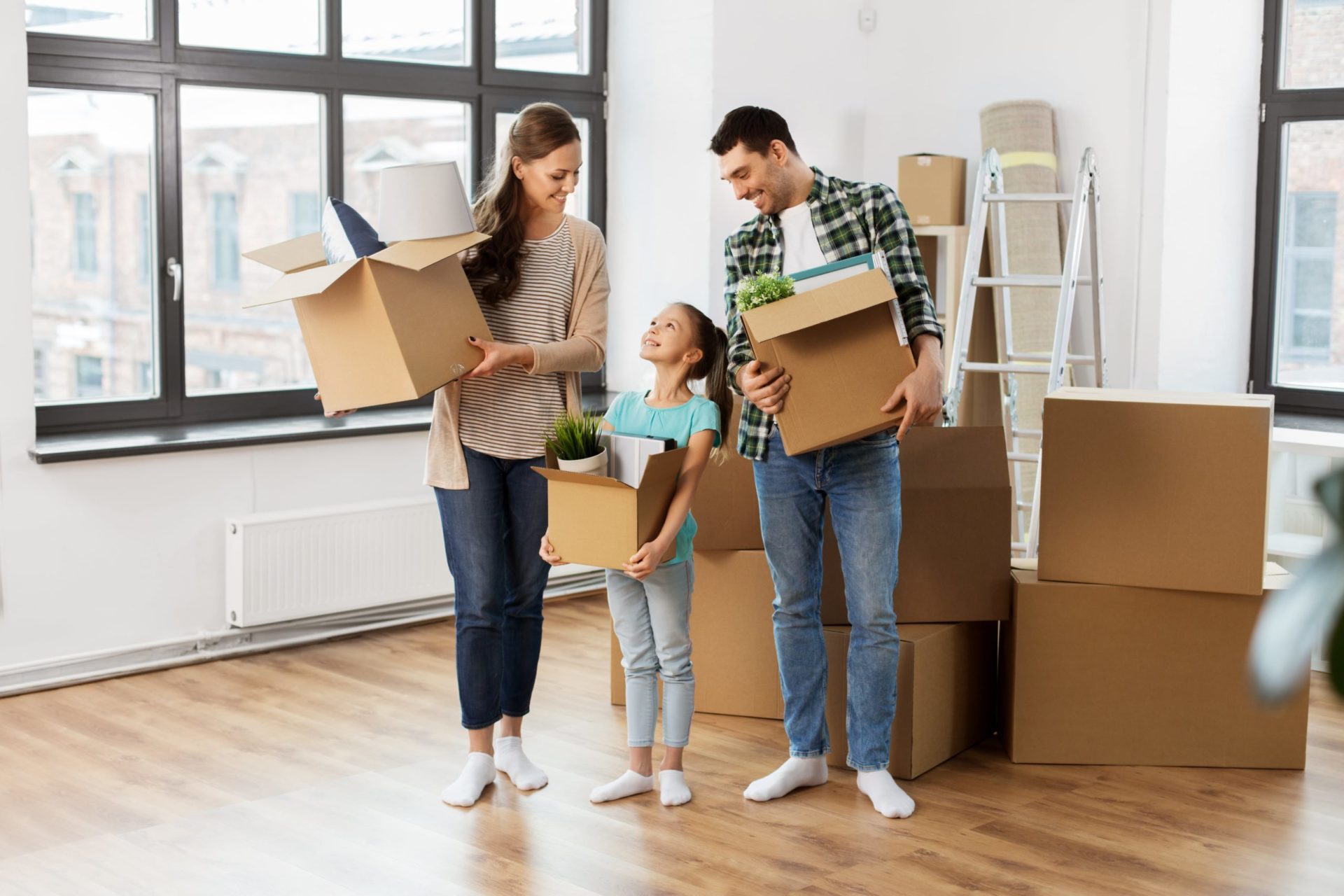A happy family with moving boxes in an empty room
